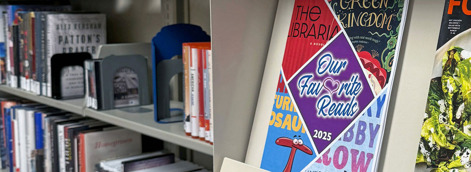 2025 Our Favorite Reads The 2025 edition of Geauga County Public Library’s "Our Favorite Reads" magazine sits on a shelf in the foreground on the right, with bookshelves in the background on the left.