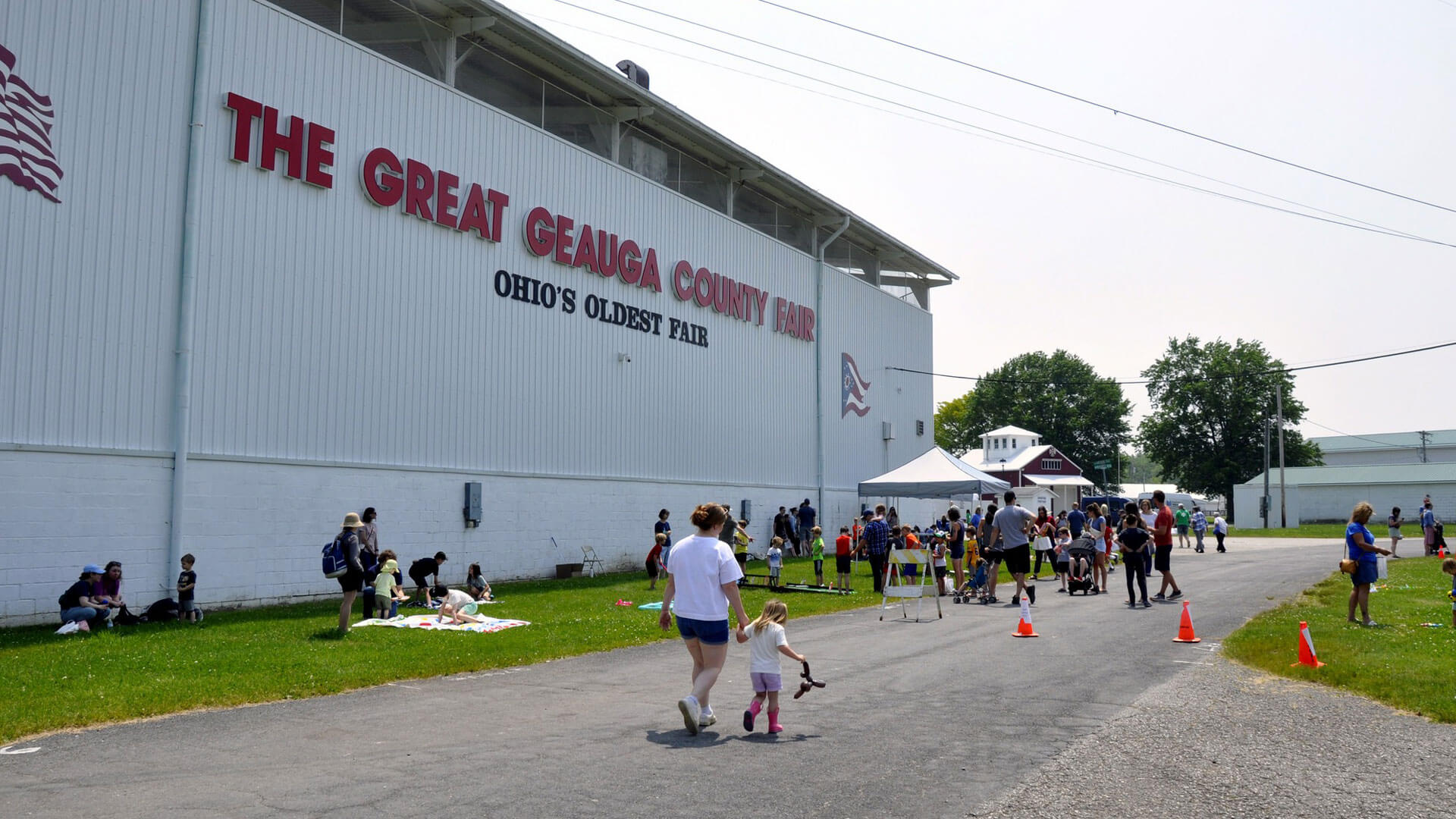 People walk, gather, and play at near a large building.